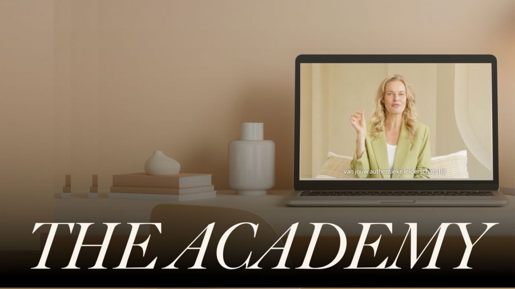 Laptop op een bureau toont een vrouw die online lesgeeft over authentiek leiderschap, met de tekst "THE ACADEMY" op de voorgrond.