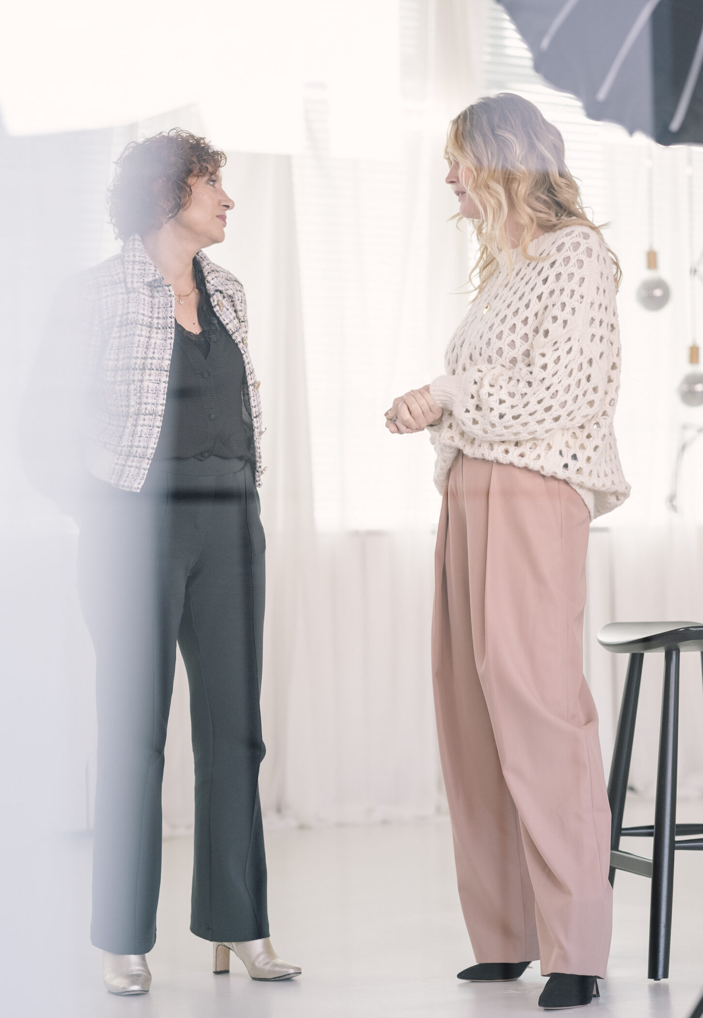 Twee vrouwelijke leiders in gesprek in een lichte, moderne ruimte.