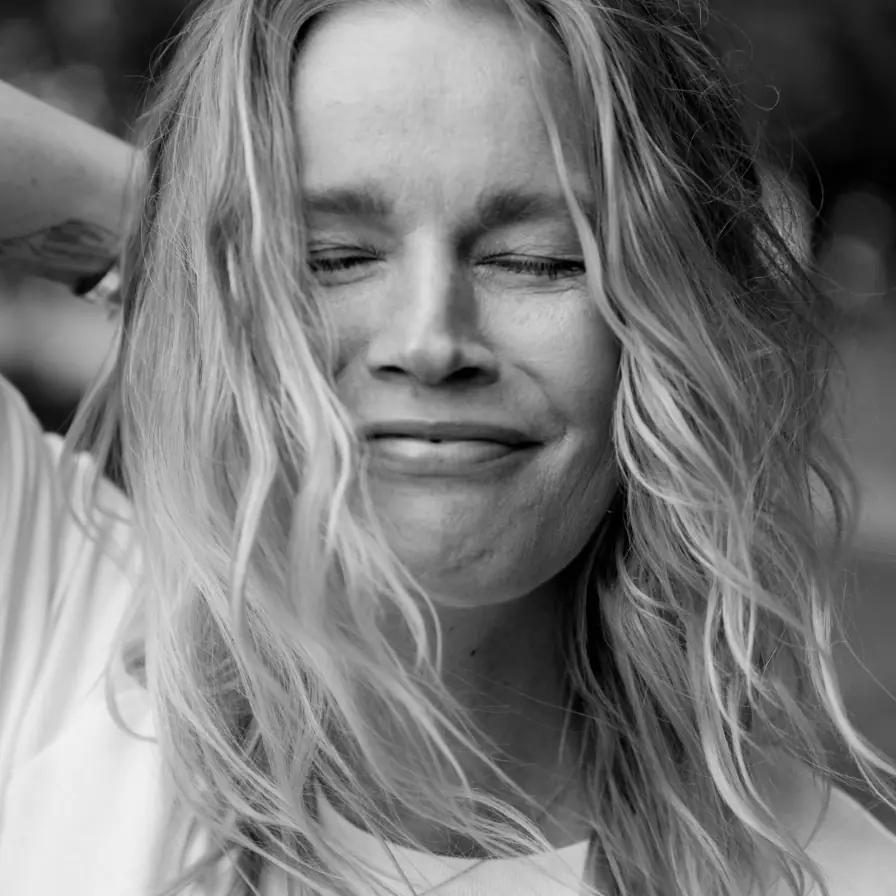 Zwart-wit portret van Caroline Glasbergen met gesloten ogen en een glimlach.