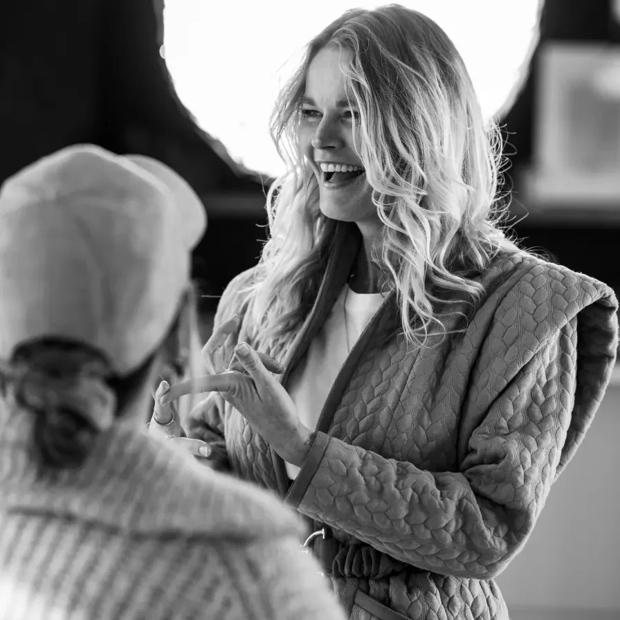 Zwart-witfoto van Caroline Glasbergen die in gesprek is met een andere persoon tijdens een mentorshipsessie.