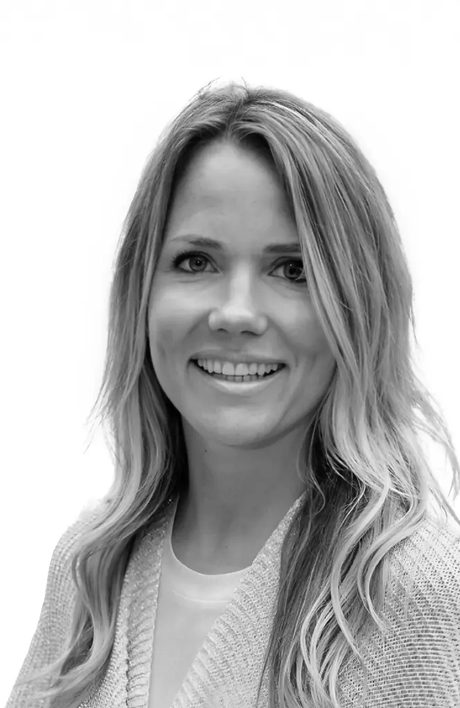 Portret van coach Ellen Dekkers met lang, golvend haar en een vriendelijke glimlach.