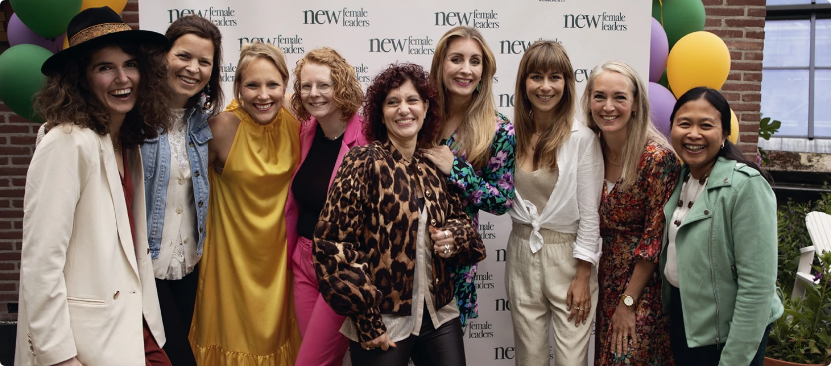 Groepsfoto van lachende vrouwen tijdens een evenement van de House of New Female Leaders community.