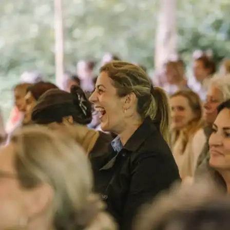 Vrouwelijke bezoekers lachen samen tijdens een inspirerende sessie op het New Female Leaders Festival – House of NFL.