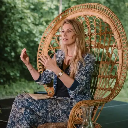 Vrouwelijke spreker deelt haar verhaal vanaf een rotan stoel tijdens het New Female Leaders Festival.